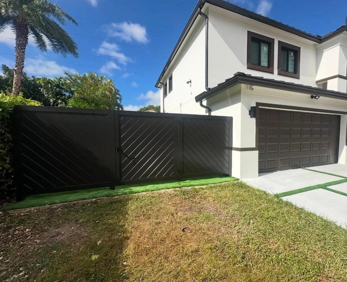 Black diagonal-slat privacy fence beside a two-car garage