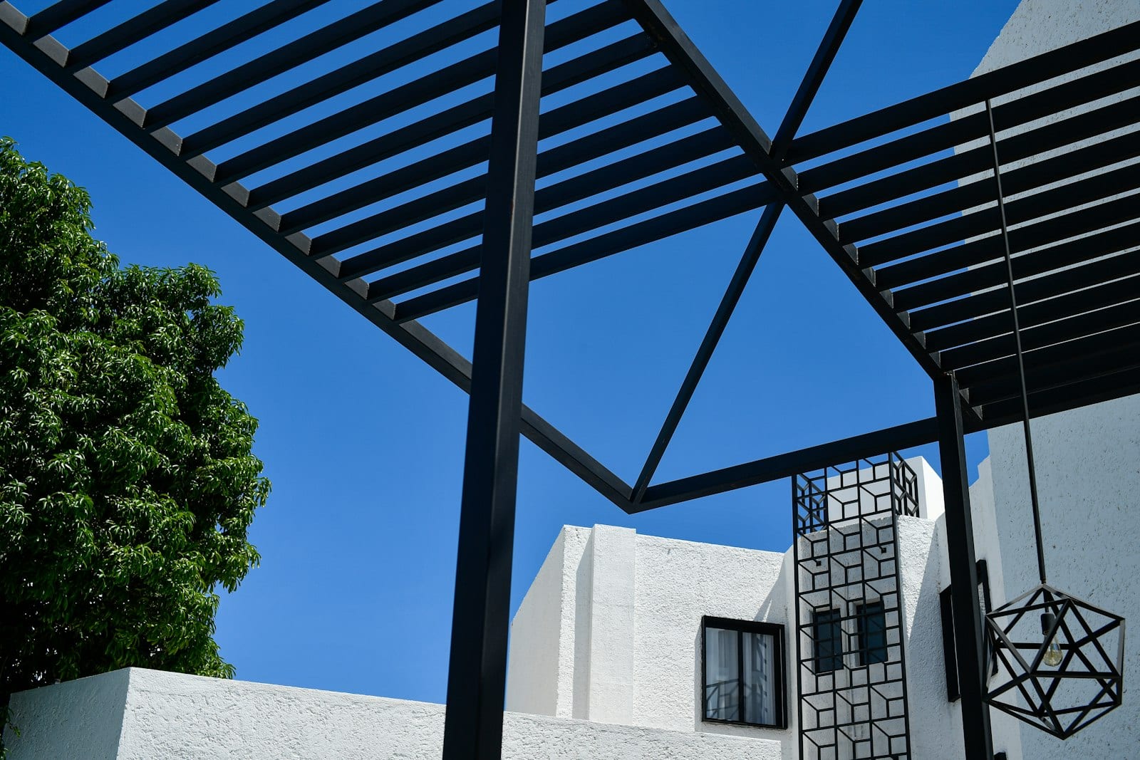 Modern black pergola against a clear blue sky